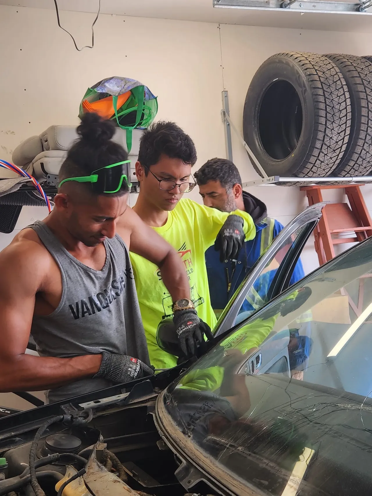 The Stealth crew, with greeat enthusiasm, working on windshield replacement