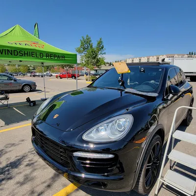 A Porsche Cayenne after a completed headlight restoration and windshield crack repair at Stealth Windshield Repair tent