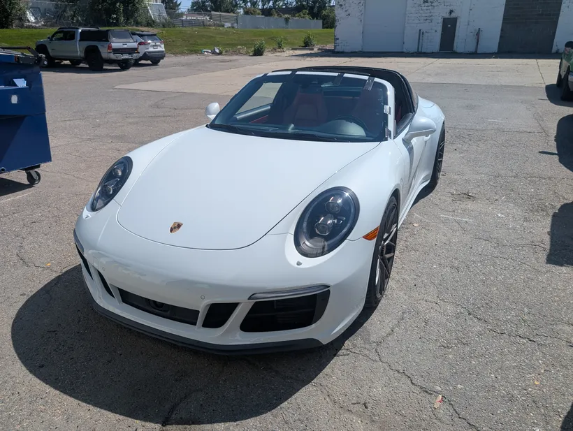 A Porsche Cayenne after a completed headlight restoration and windshield crack repair at Stealth Windshield Repair tent