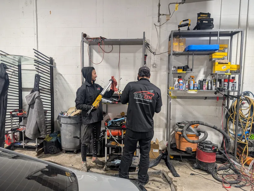 Stealth techniacians readying equipment prior to windshield replacement in a Stealth garage